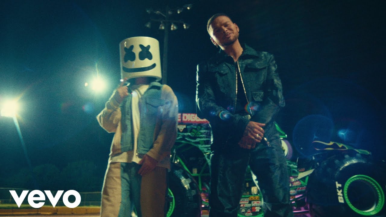 Marshmello and Kane Brown standing in front of the Grave Digger Monster Jam truck
